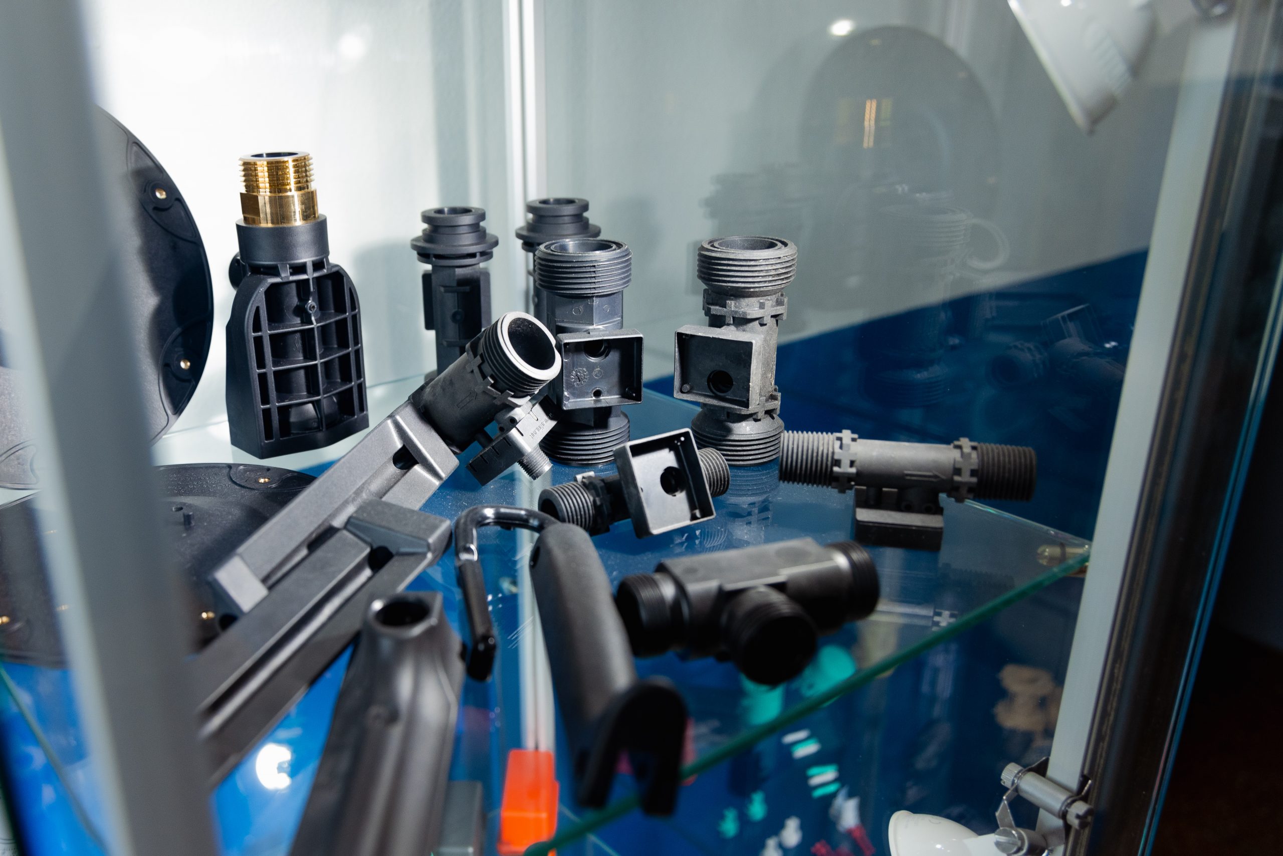 Vitrine mit verschiedenen Spritzgussteilen